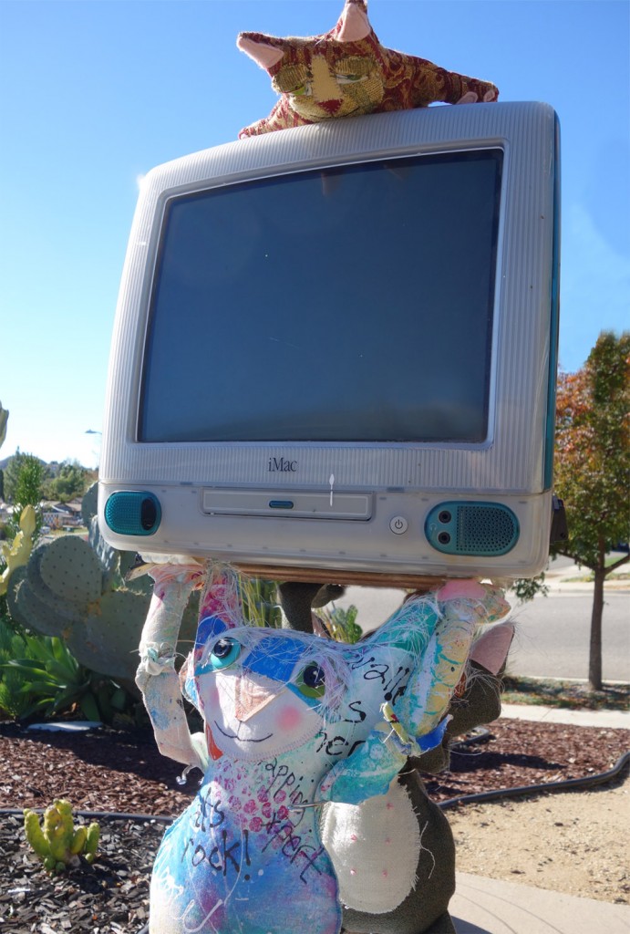 Two Cat dolls carrying an iMac computer.