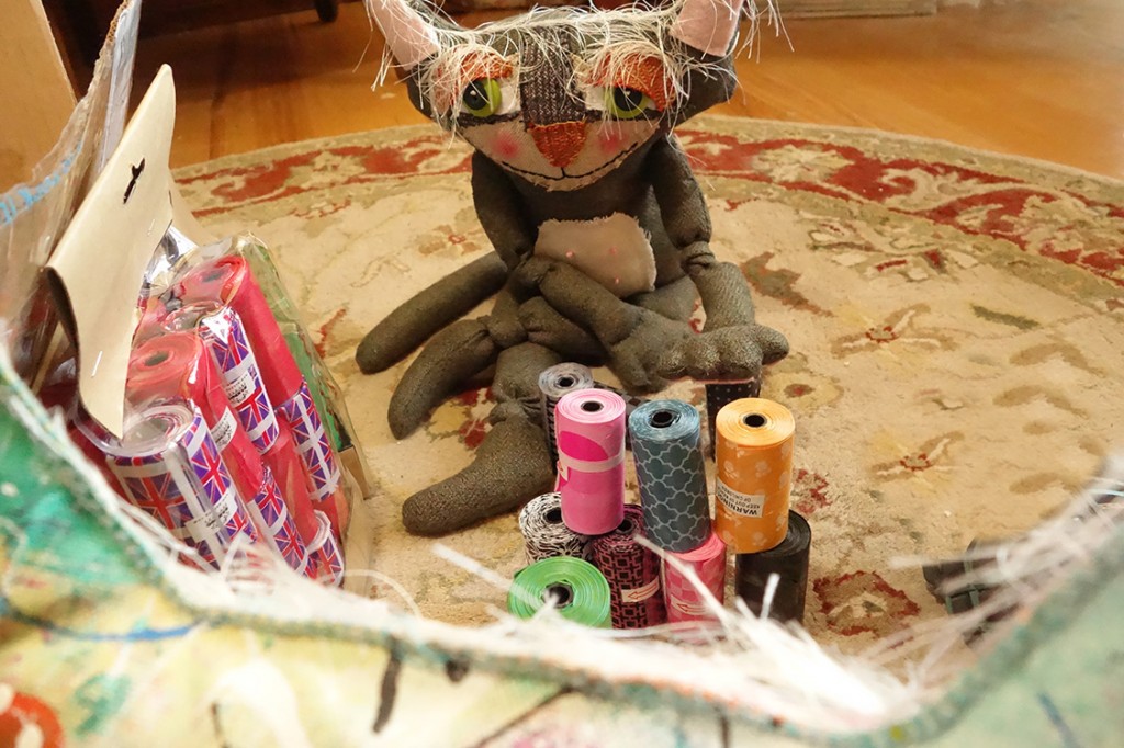 Cat doll in deep concertration while stacking the brightly colored objects.