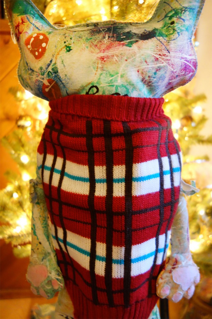 The Chairman doll showing the plaid and colorful backside of the dog sweater he is wearing.