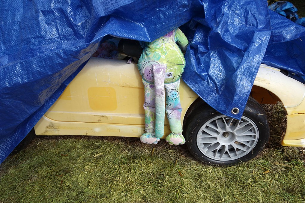 Dude's backside hanging out of the car as it is still partially covered with the tarp.