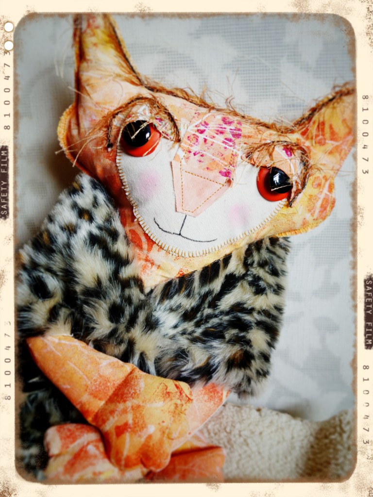 A sweet and full-throttle beauty shot of Ginger the soft scuptured cat doll wraped in and animal skin fluffy fabric.