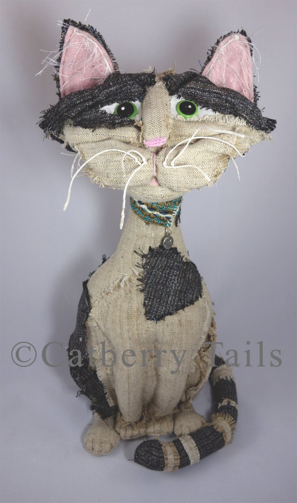 Opie the Soft sculptured cat dall stands about 18 inches tall and is made out of recycled mens' suits. 