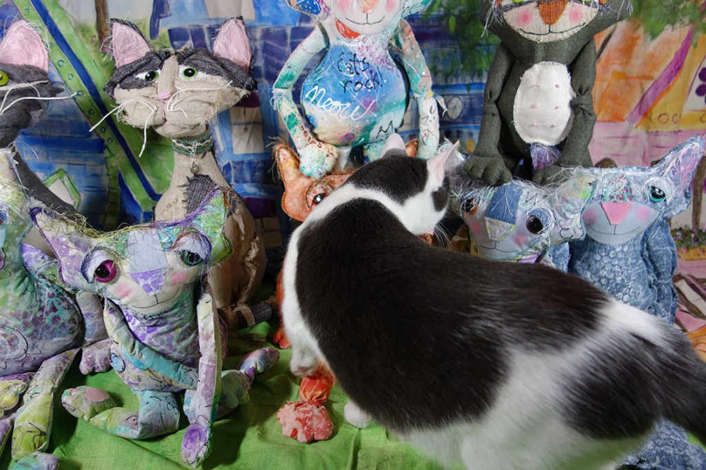 Wally, the real life cat, inspects the dolls as they pose for their group photo.