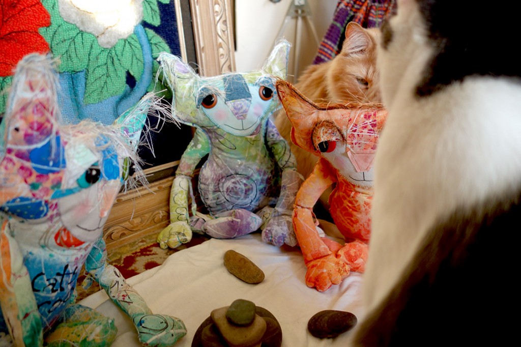 Wally and Rudy, two real life cats, sit watching the cat dolls with their rocks.