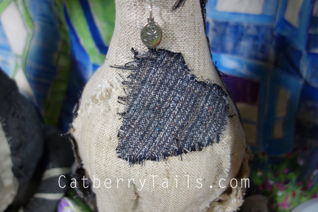 Closeup of a tweed heart patch on the chest of the Opie Doll Magnificat.