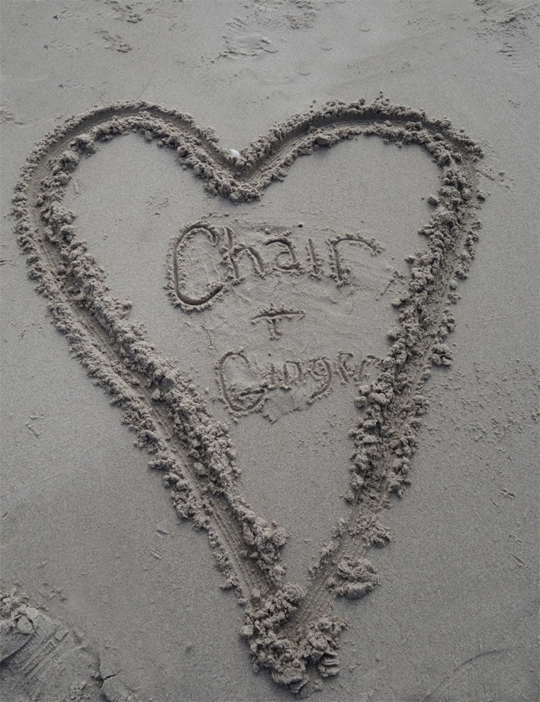 A sand painting made by the Chairman in the sand at the beach. It's a heart with Chair plus Ginger written in it.