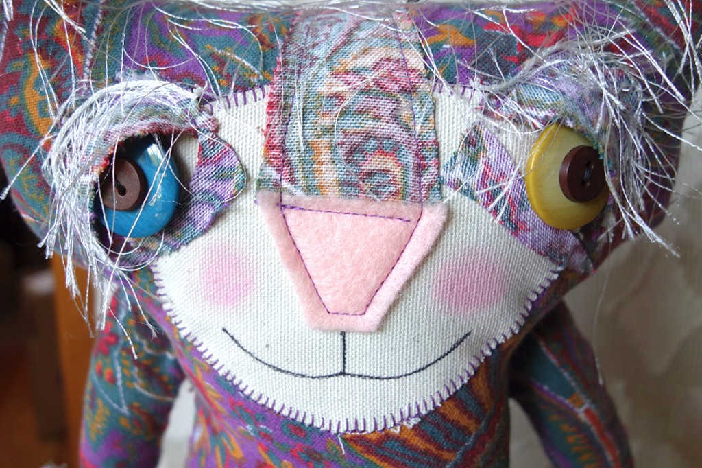 Extreme closeup of a very colorful and cure cat doll.