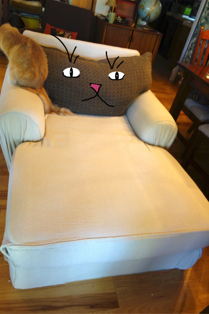 Photo of the almost finished chaise but the back pillow does indeed look like a cat head and there are eyes, a nose and mouth drawn in to prove it.