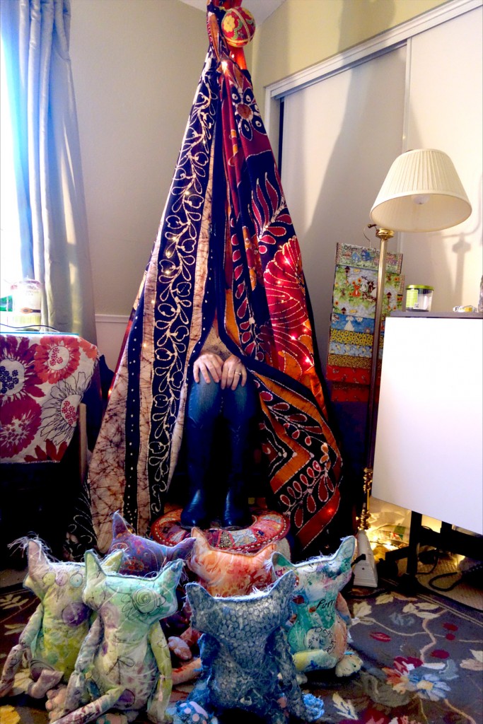 Cat dolls are sitting in front of an indoor tepee. All we see of the Kreatrix is her legs sticking out.