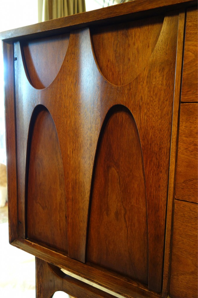Detail photo of a sculptural wood detail on the door of the credenza. Very modern. Very cool.