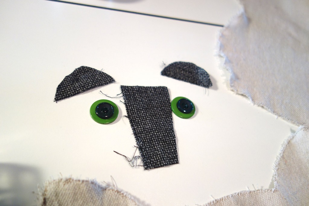 Button eyes and a fabric nose lay on a table.