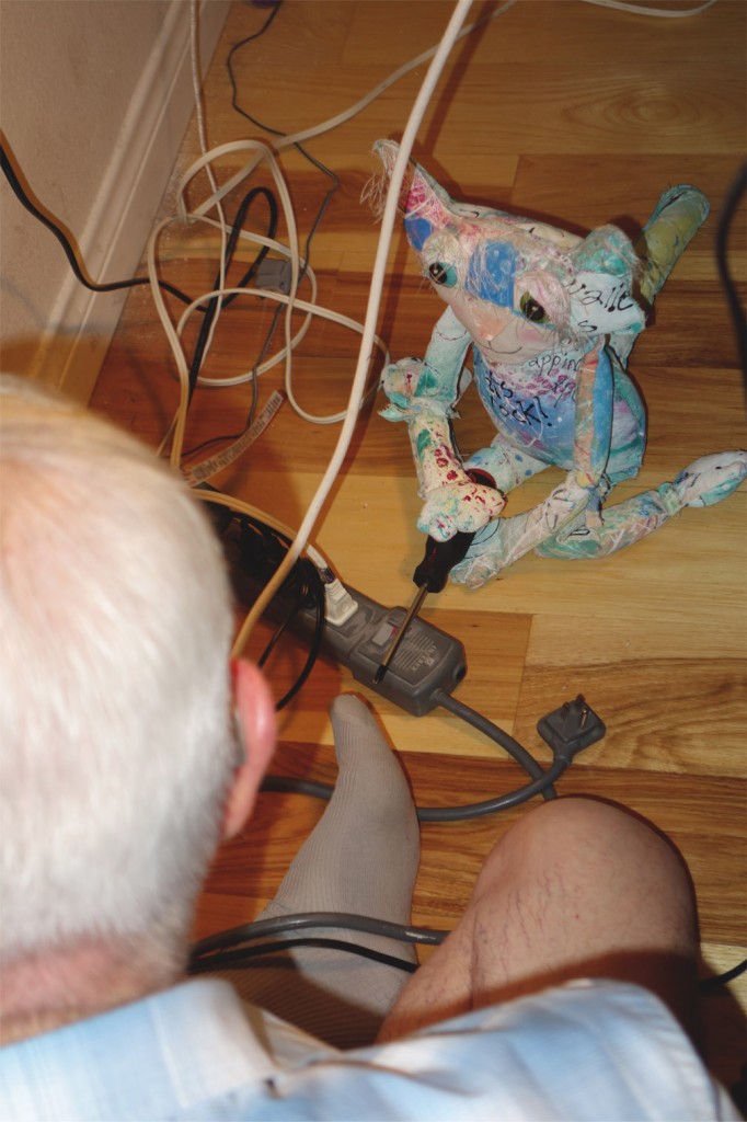 The Prof's father repairs a wall socket and The Chairman hands him a tool.