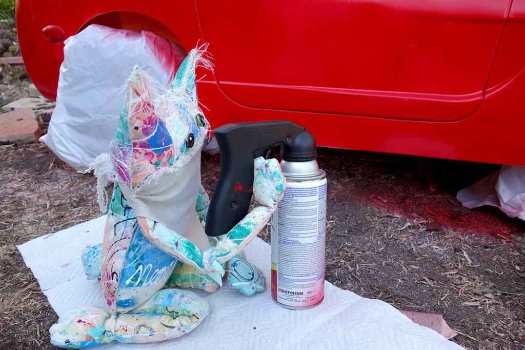 The Chairman is aiming the spray can at his bright red corvette, also known as The World Dominationmobile.