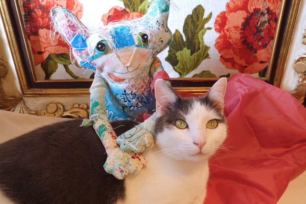 The Chairman has his paws around real life cat, Wally, who has jumped up on the counter to comfort the Chairman.