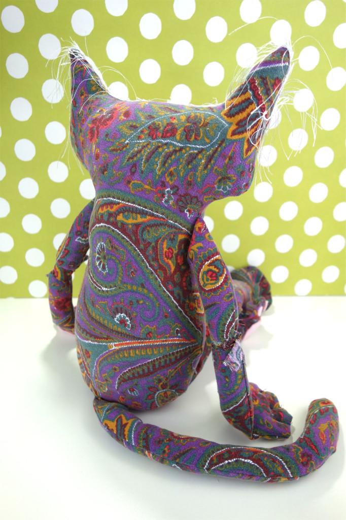 Penny is shown from the back. You can really see the paisley pattern in the vintage fabric. Her arms and paws rest by her side.