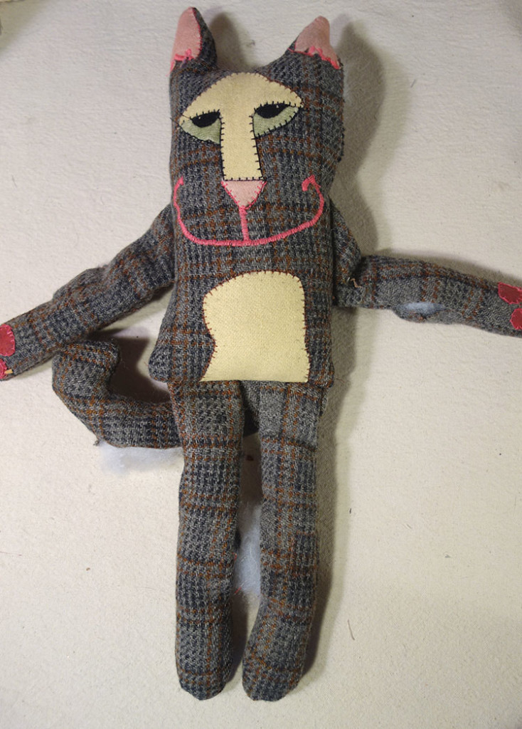 A partially finished cat doll made from a man's suit. It's a little stiff but the face is cute.