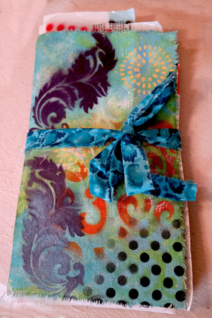 Very colorful, large hand painted journal with a ribbon tied around it.