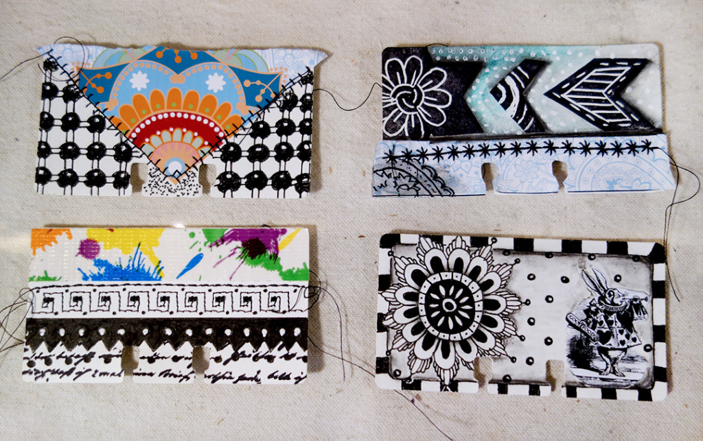 Colorful rolodex cards decorated with scraps of paper, sewn threads and drawing.