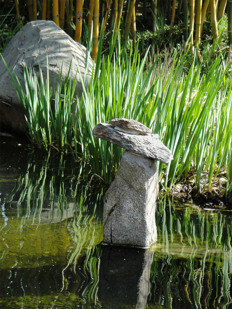 A very beautiful zen-like photo of rocks balanced in a Japanese Koi pond. Very serene.