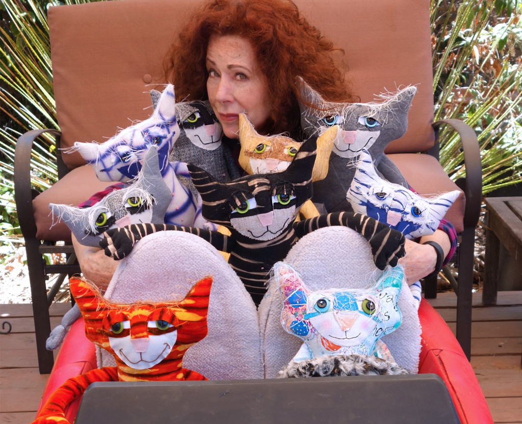 The creator of Catberry Tails poses with the Chairman and numberous soft sculpture cats. 