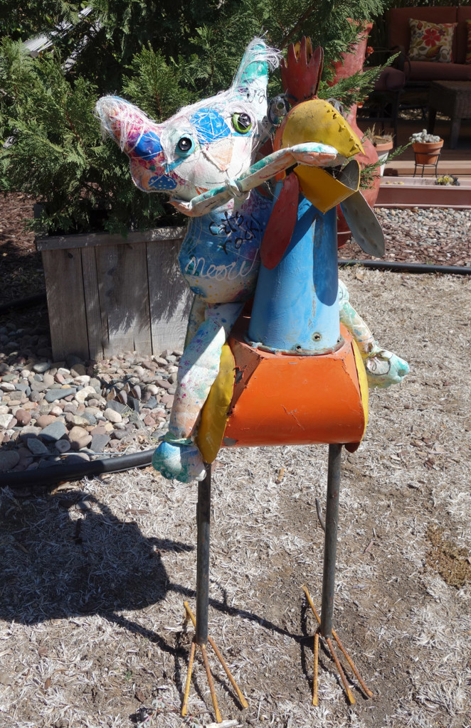 The Chairman is sitting on a large and colorful metal rooster.