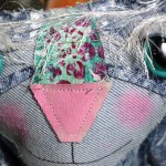 Closeup of a denim cat dolls adorable face made from hand painted demin fabric.